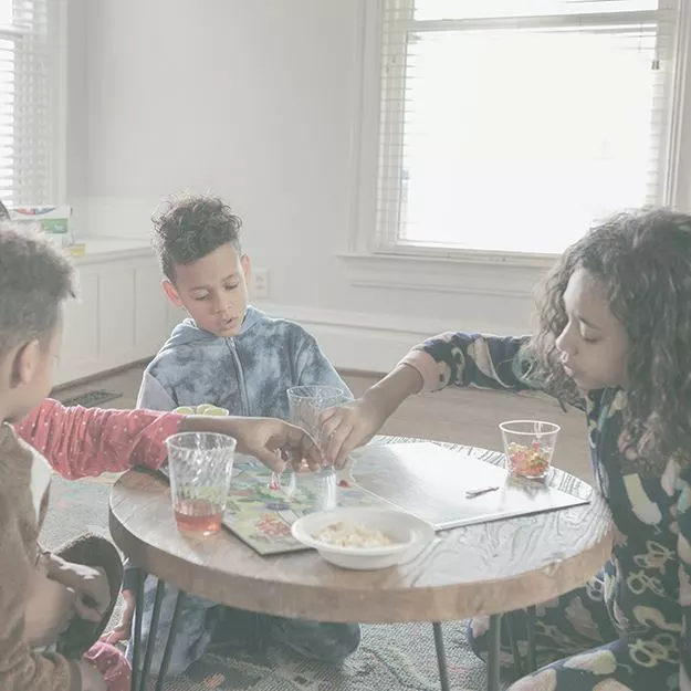 Mom and three children playing a board game