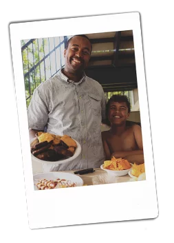 Instax picture of a father and son holding a Chinet Classic plate full of cheeseburgers