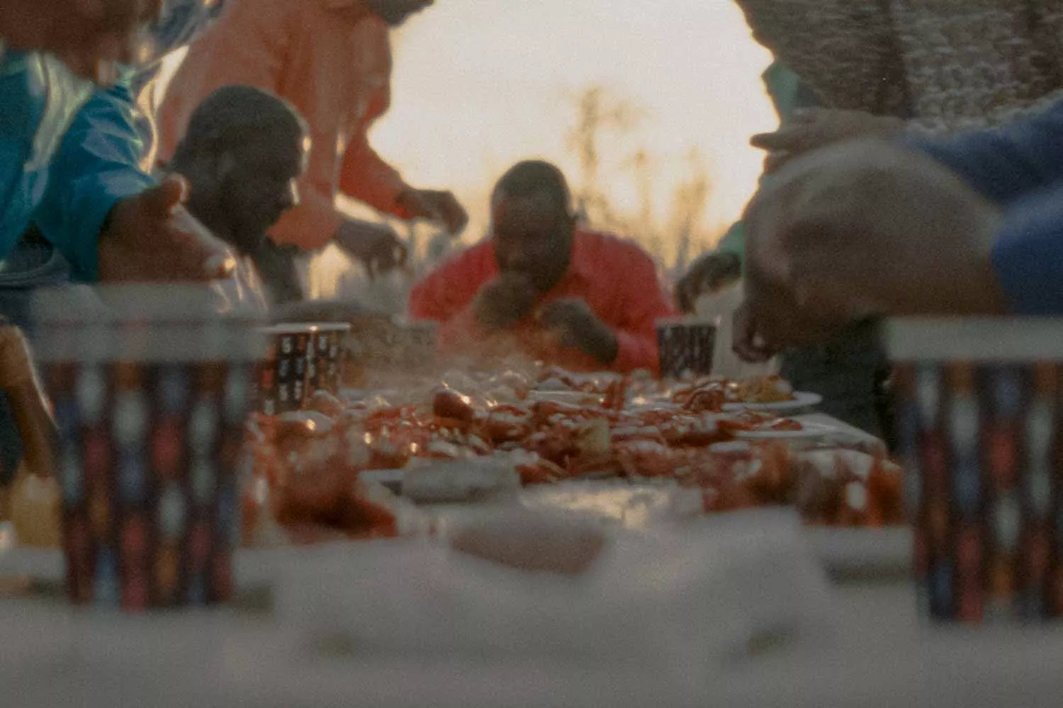 504 Boyz gathered around a table enjoying a crawfish boil and beverages in Chinet Comfort® cups
