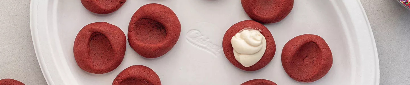 Red velvet thumbprint cookies on a Chinet Classic plate