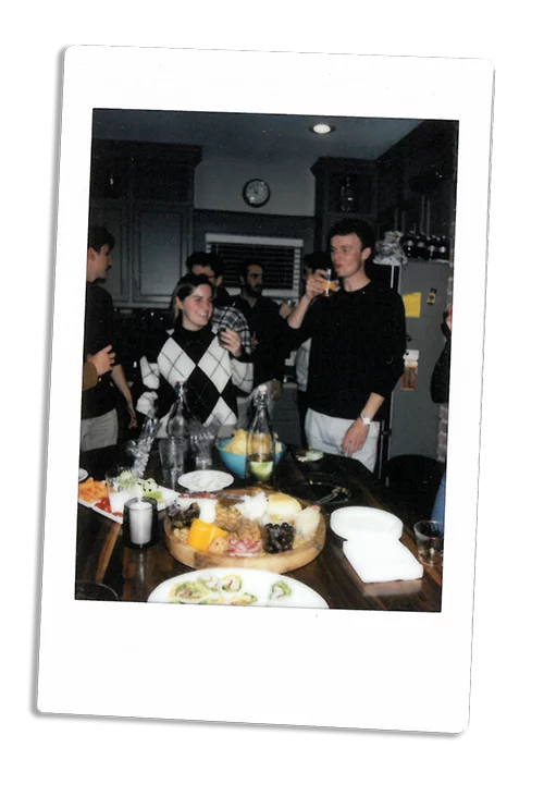 Instax picture of a group of friends eating around a kitchen counter